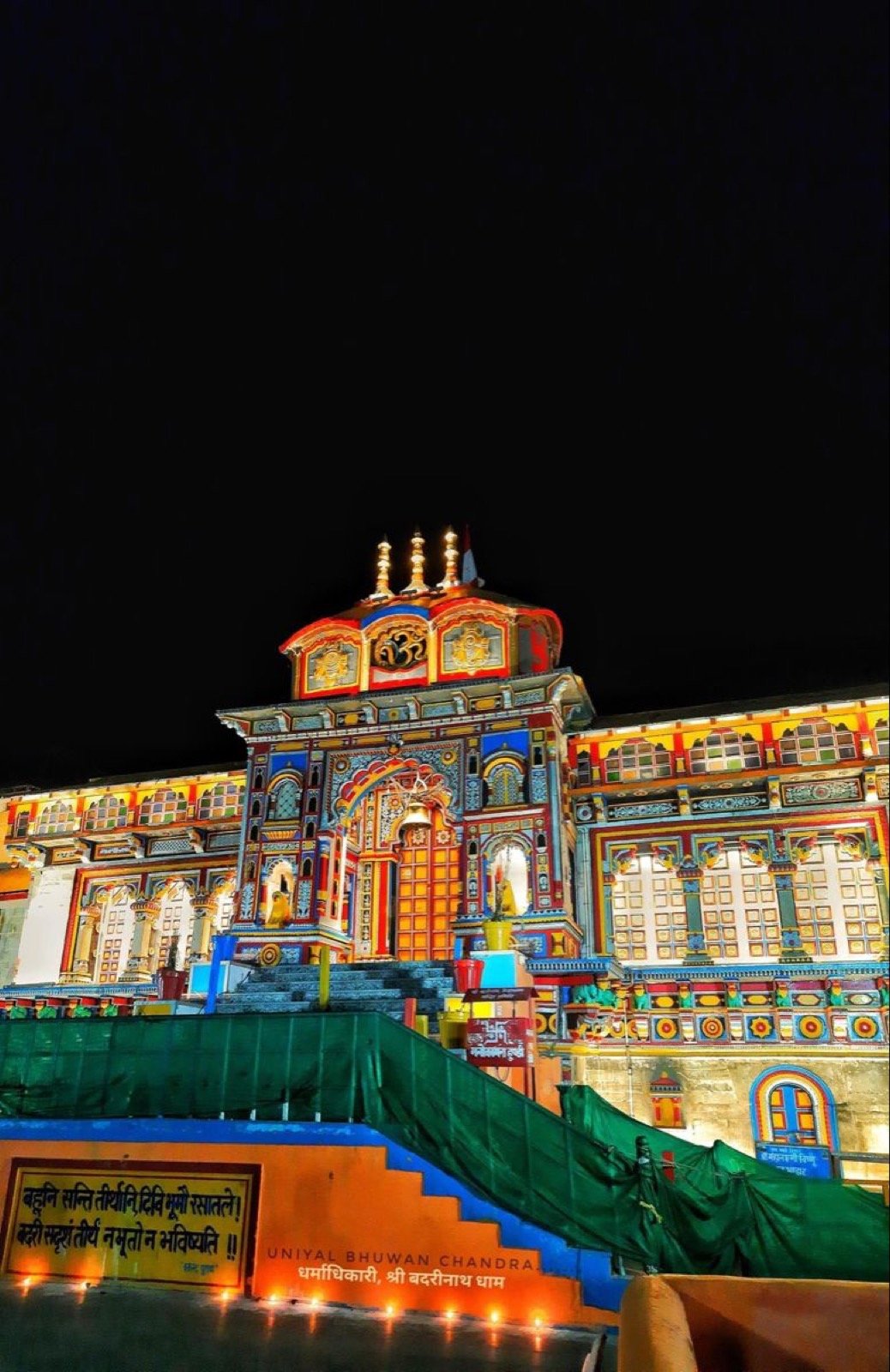 Badrinath temple with colourful facade and snow peaks